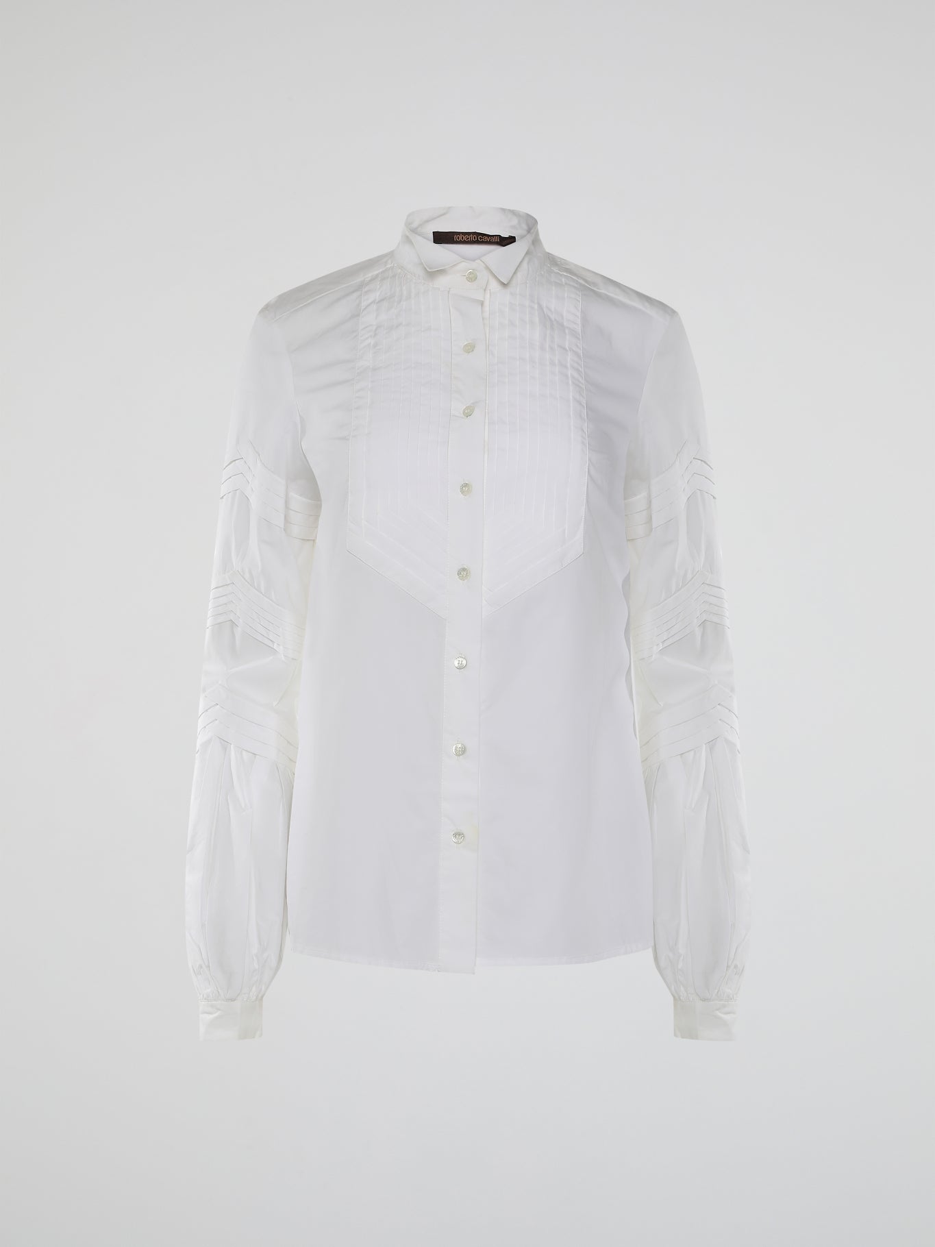 Step into the world of timeless elegance with the White Pleated Bib Shirt from Roberto Cavalli. Crafted with meticulous attention to detail, this masterpiece combines effortless sophistication with a touch of whimsical charm. From its delicate pleated bib to its crisp white fabric, this shirt will make a statement in any setting, exuding refined elegance that is truly captivating.