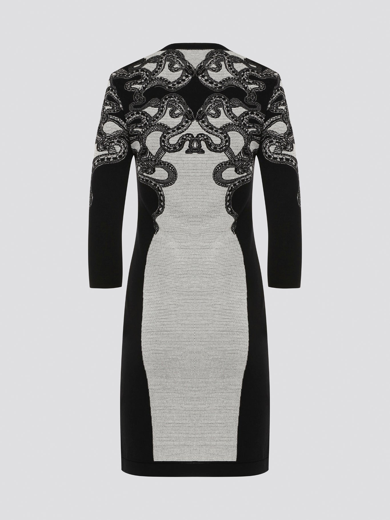 Feel fierce and fabulous in this Roberto Cavalli snake detailed knitted dress. The intricate serpent design adds a touch of exotic glamour to this form-fitting silhouette. Step out in style and make a statement in this one-of-a-kind piece.